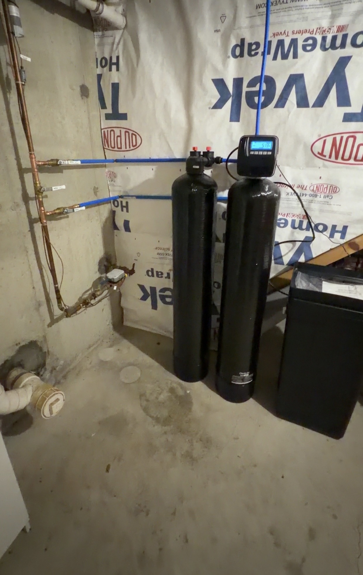 An Absolute Water Solutions softener and whole-house carbon installation with blue piping and a separate brine tank.